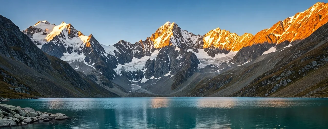 Mountain peaks reflected in a blue alpine lake.